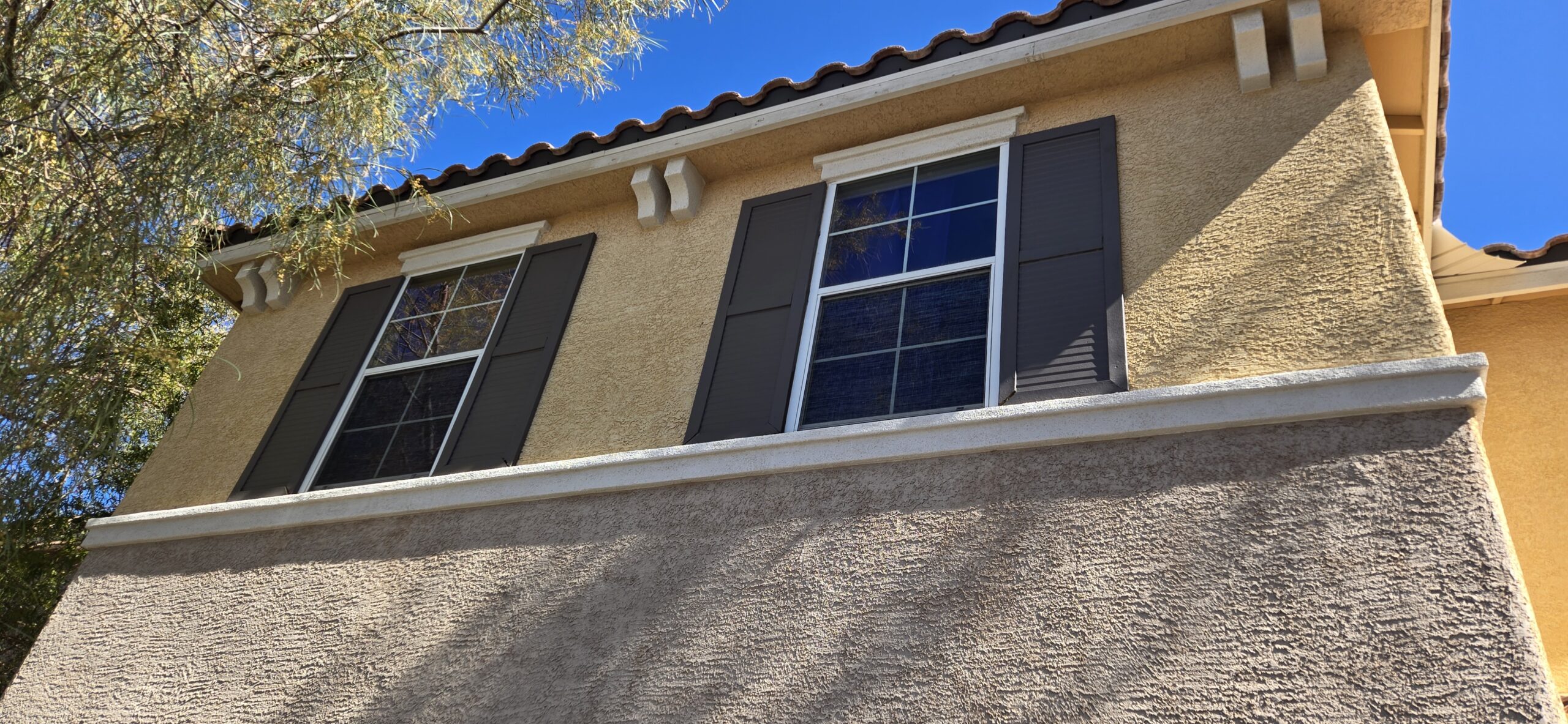 Stucco fascia and tile roofline repainted by New Visions Painters in Las Vegas