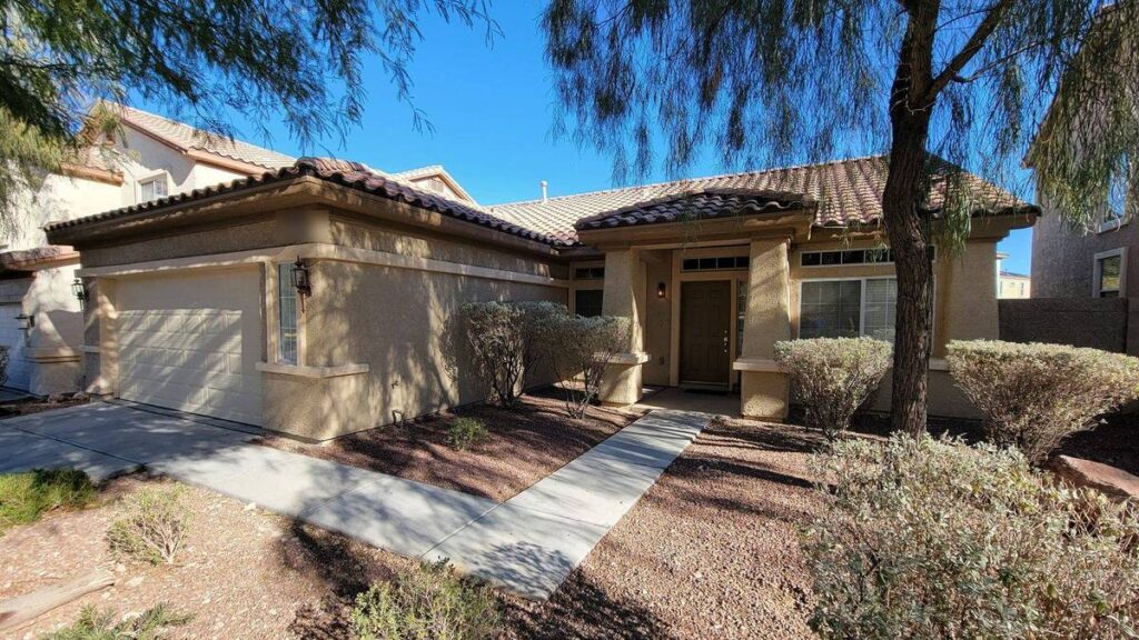 Newly repainted single-story stucco home exterior in Las Vegas under clear blue sky