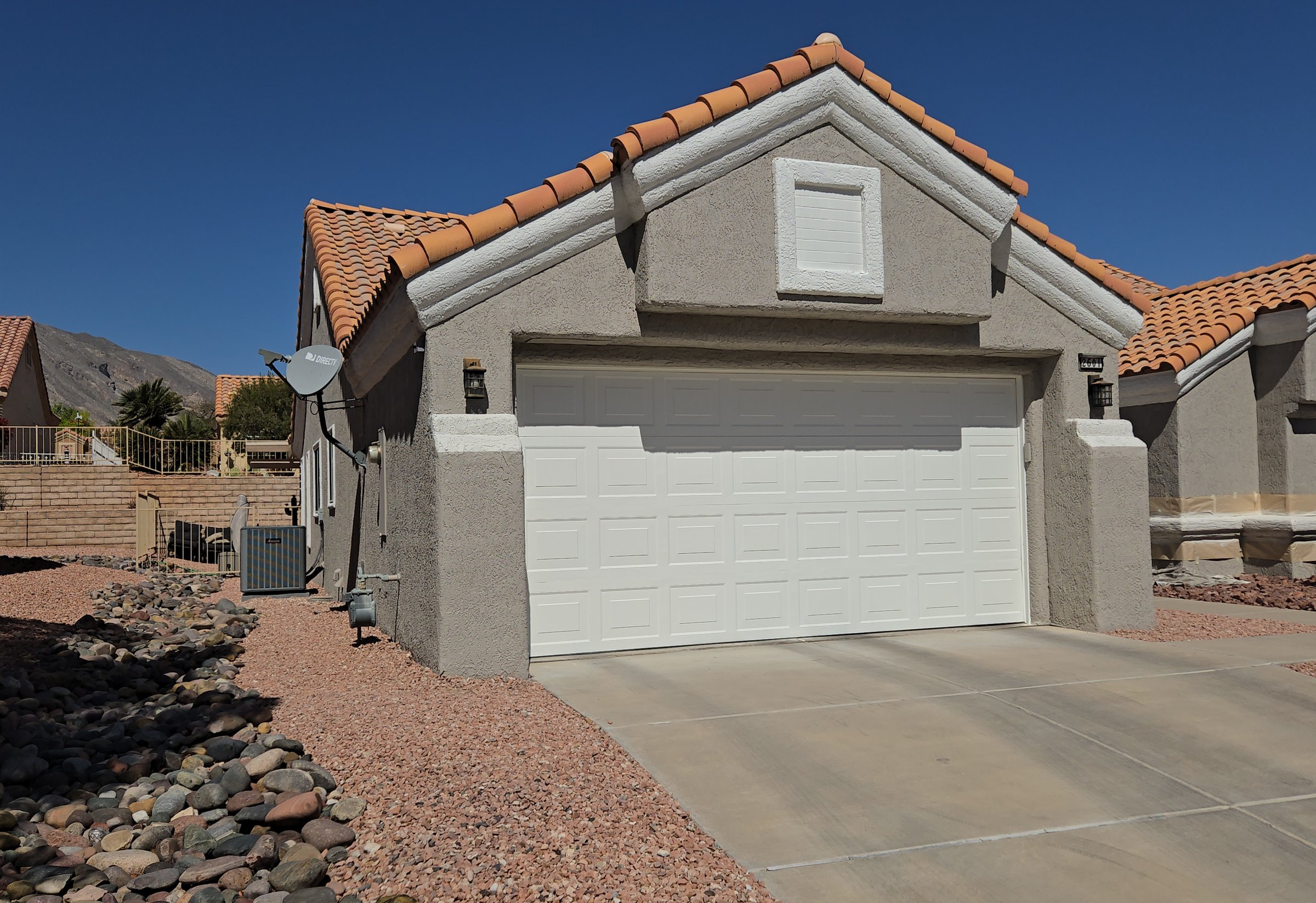 Single-story tile-roof home in Green Valley, Henderson NV, mid exterior repaint with a freshly painted garage door