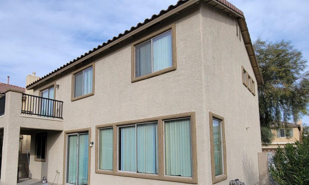 Two-story tan stucco home exterior prepped for repainting in Mountain's Edge, southwest Las Vegas