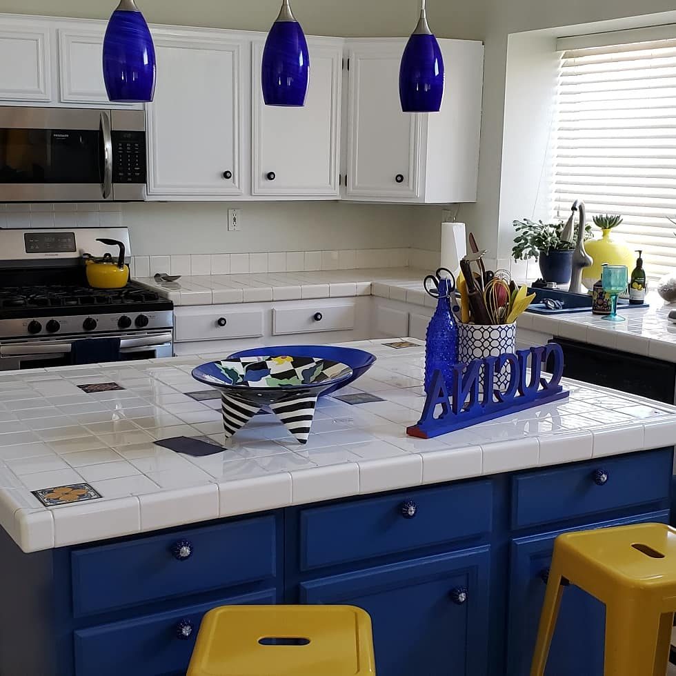 Two-tone kitchen with white upper cabinets and blue island in Las Vegas